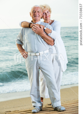 man and woman standing on the sea shore man and woman standing on the sea shore 73338637