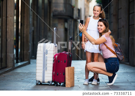 Woman with little daughter traveling together, taking selfie Woman with little daughter traveling together, taking selfie 73338711
