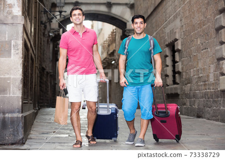 Two men are walking to culture center with baggage Two men are walking to culture center with baggage 73338729
