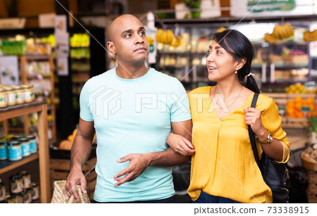 Latin american family couple shopping in food department of supermarket Latin american family couple shopping in food department of supermarket 73338915