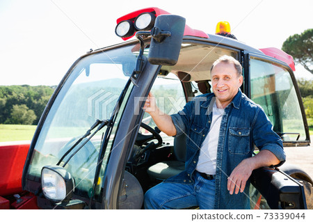 Portrait of male farmer in the special car at the cow farm. Portrait of male farmer in the special car at the cow farm. 73339044