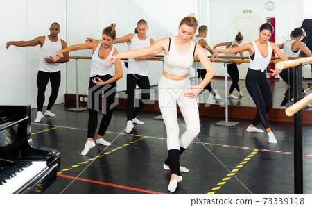 Sporty guys and girls performing dance elements Sporty guys and girls performing dance elements 73339118