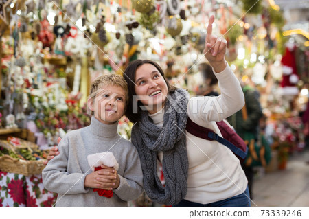 Preteen boy having fun at Christmas fair with mother 73339246