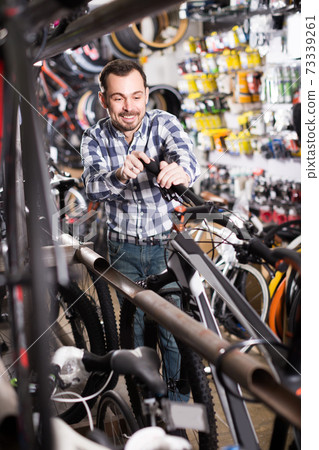 Man is looking for bicycle handlebars Man is looking for bicycle handlebars 73339261