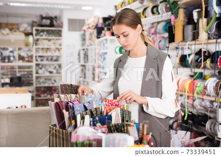 Girl choosing ribbons for needlecraft Girl choosing ribbons for needlecraft 73339451