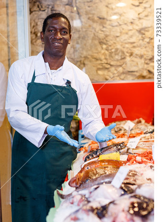 Salesman portrait in fish shop 73339521