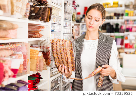 Girl choosing ribbons for needlecraft Girl choosing ribbons for needlecraft 73339525