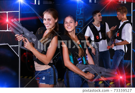 Two girls posing with laser guns Two girls posing with laser guns 73339527