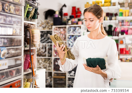 Girl choosing ribbons for needlecraft 73339554
