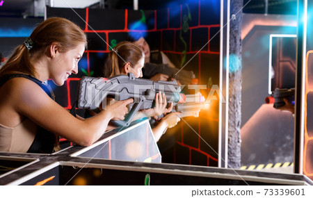 Smiling people in vests and with laser pistols playing emotional Smiling people in vests and with laser pistols playing emotional 73339601