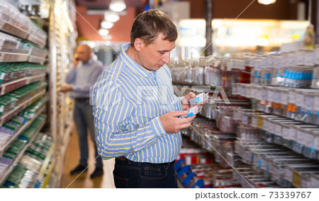 Positive man buying fasteners, screws, nails 73339767