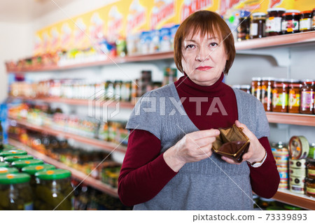 Unhappy mature female buyer with empty purse and canned Unhappy mature female buyer with empty purse and canned 73339893