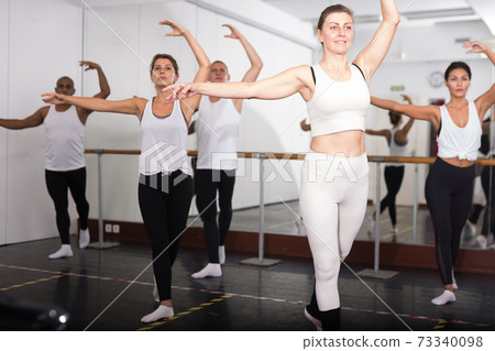 Sporty guys and girls performing dance elements Sporty guys and girls performing dance elements 73340098