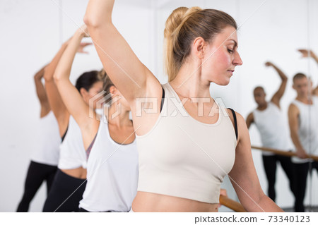 Concentrated women and men rehearsing ballet dance Concentrated women and men rehearsing ballet dance 73340123