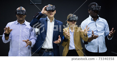 People using virtual reality glasses delighted with videogames People using virtual reality glasses delighted with videogames 73340358