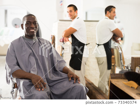 Happy African male client of barbershop 73340374