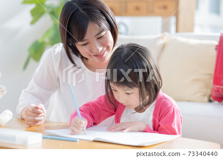 Family image Girl doing homework with mom 73340440