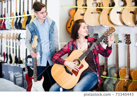 Young rock-n-roll players are choosing between acoustic and electric guitar Young rock-n-roll players are choosing between acoustic and electric guitar 73340443