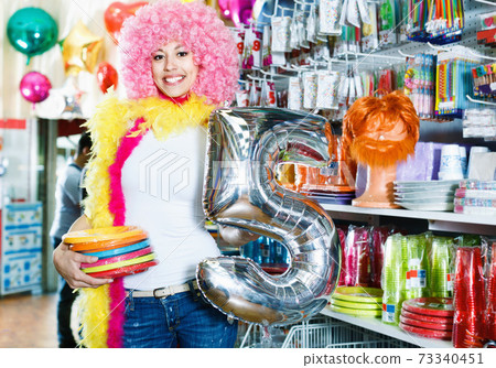 Woman preparing to fest and choosing clown wig 73340451
