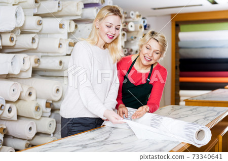 Woman seller displaying diverse fabrics 73340641