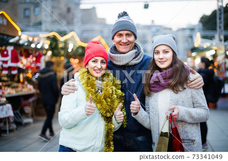Portrait of family couple with teen girl at Christmas fair Portrait of family couple with teen girl at Christmas fair 73341049