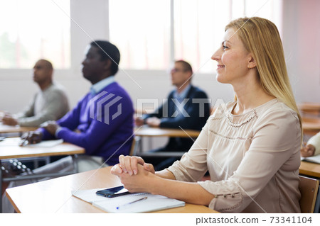 Cheerful woman listening lecture during adult education class 73341104