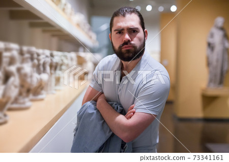 Man looking at stone architectural elements in historical museum hall Man looking at stone architectural elements in historical museum hall 73341161