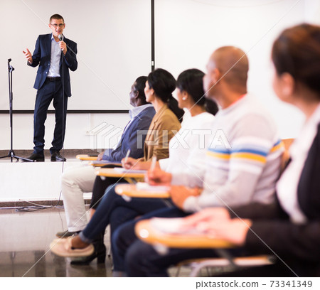 Male coach giving speech at conference hall 73341349