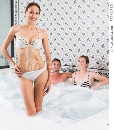Sexy woman in jacuzzi with friends 73341730