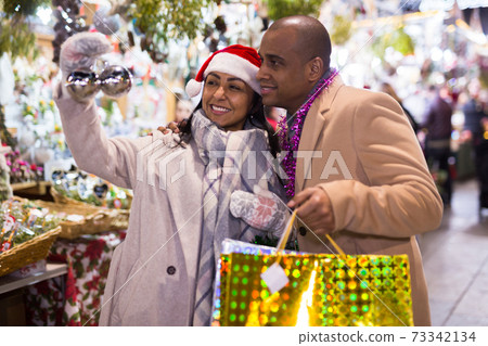 Emotional happy couple buying christmas balls at christmas fair 73342134