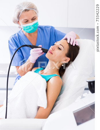 Young female getting facial cryolipolyse Young female getting facial cryolipolyse 73342229