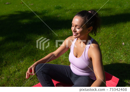 Smiling woman practicing asana outdoor.Healthy life style and life balance Smiling woman practicing asana outdoor.Healthy life style and life balance 73342408
