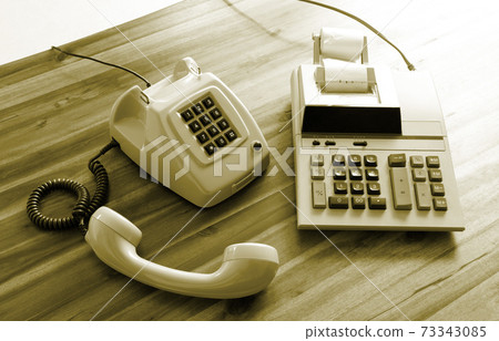 Old fashioned calculator and telephone Old fashioned calculator and telephone 73343085