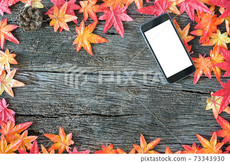 Autumn leaves and mockup mobile phone on wooden nature background with copy space. 73343930