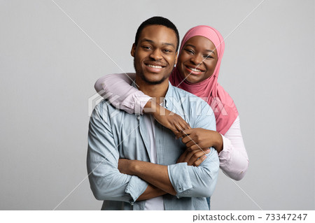 Portrait of loving african american muslim couple posing on grey 73347247