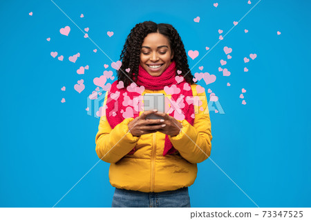 Black Woman Texting On Phone Sending Hearts On Blue Background Black Woman Texting On Phone Sending Hearts On Blue Background 73347525