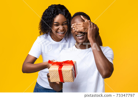 Cheerful african woman making Valentine surptise for her husband Cheerful african woman making Valentine surptise for her husband 73347797