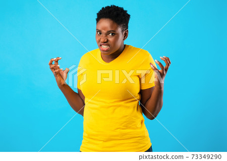 Mad African Woman Freaking Out Looking Angrily Posing, Blue Background 73349290