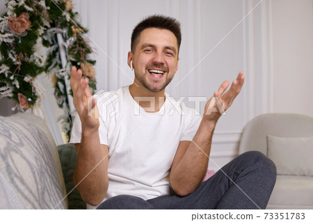 young man in earphones is talking to somebody 73351783