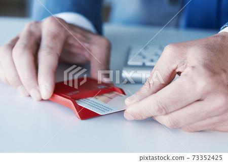 man insearting an electronic identification in a reader man insearting an electronic identification in a reader 73352425