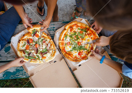 Group of children with pizza in the open box 73352619