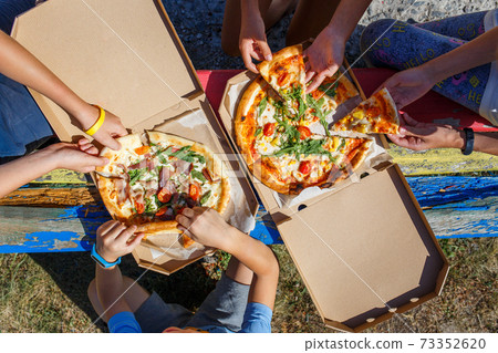 Group of children with pizza in the open box 73352620