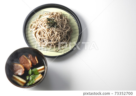 Photographed hot duck seiro soba with roasted duck meat, grilled green onions and trefoil on a white background (overhead view) 73352700