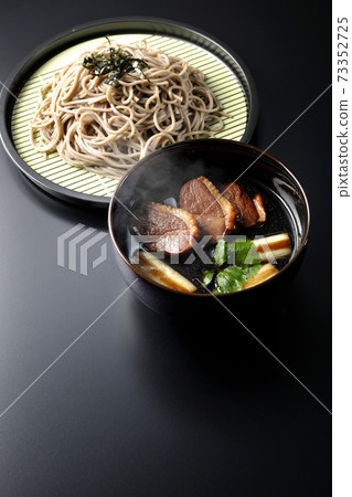 Photographed hot duck seiro soba with roasted duck meat, grilled green onions and trefoil on a black background Photographed hot duck seiro soba with roasted duck meat, grilled green onions and trefoil on a black background 73352725