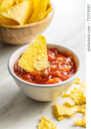 Tortilla chips and red tomato salsa dip. Mexican nacho chips. 73353083