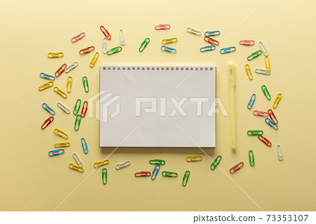 Open spiral notepad on yellow background Open spiral notepad on yellow background 73353107