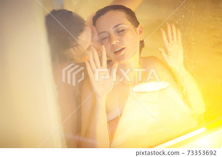 soft focus. naked man and woman take shower together in bathroom with window soft focus. naked man and woman take shower together in bathroom with window 73353692