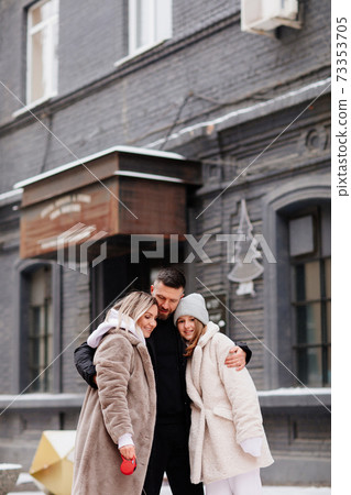 beautiful family with dog on a leash on street. photo shoot. 73353705
