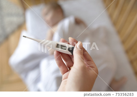 Electronic thermometer with empty display in mother hand 73356283