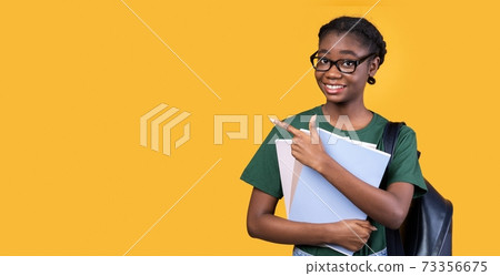 Black Female Student Pointing Finger Aside Standing Over Yellow Background 73356675